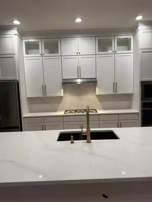 White kitchen with quartz island completed by Braga Remodeling