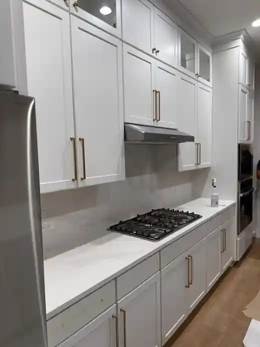 Custom white kitchen cabinetry and cooktop project by Braga Remodeling