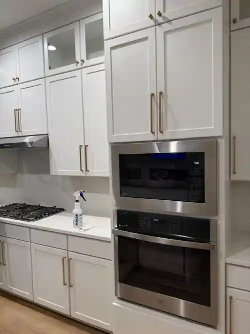 Built-in oven and microwave wall with white cabinetry by Braga Remodeling
