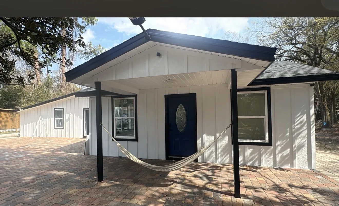 White home exterior with black trim and blue entry door finished by Braga Remodeling in Jacksonville, FL