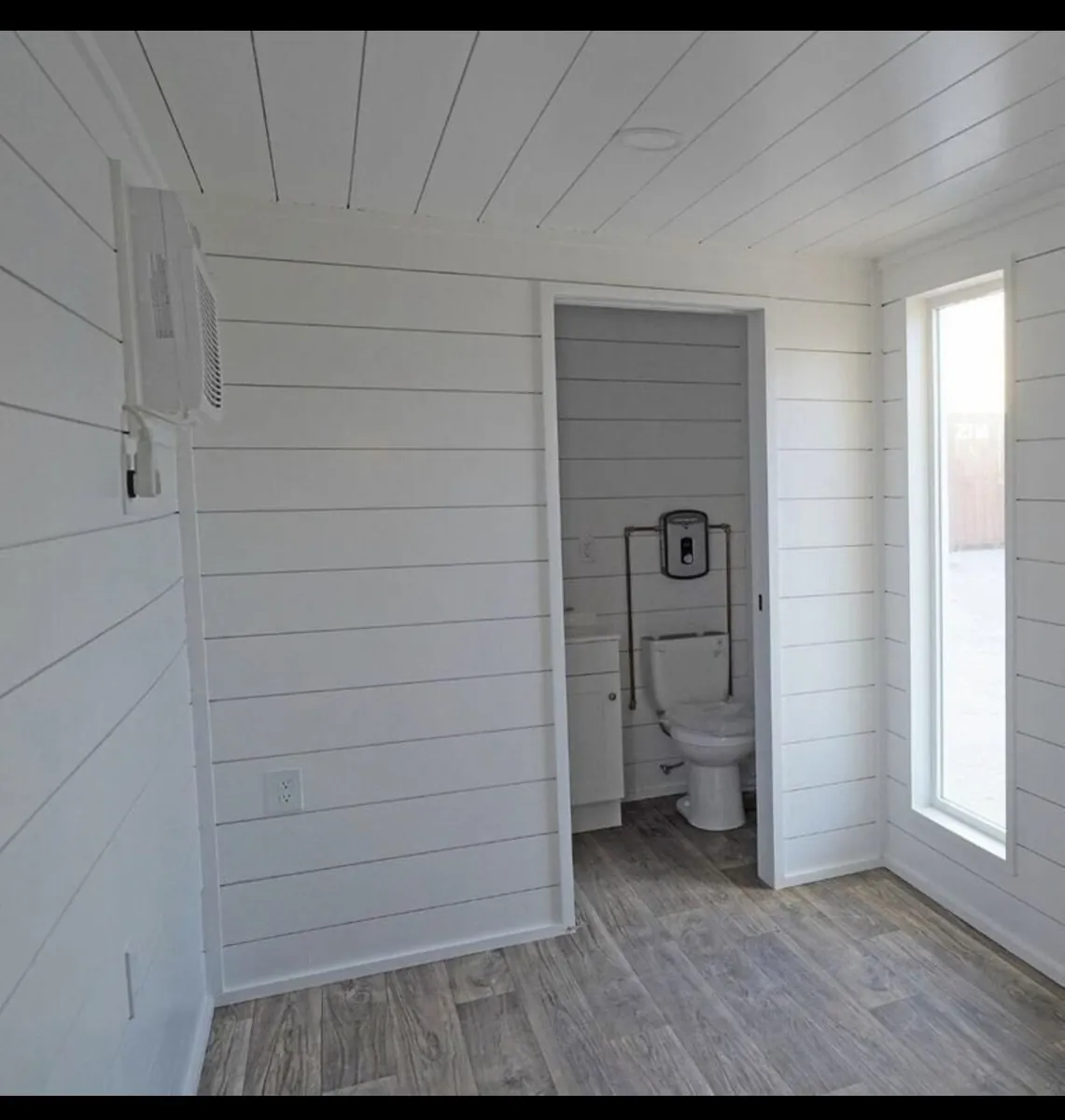 Bathroom with shiplap wall detail and tile floor by Braga Remodeling