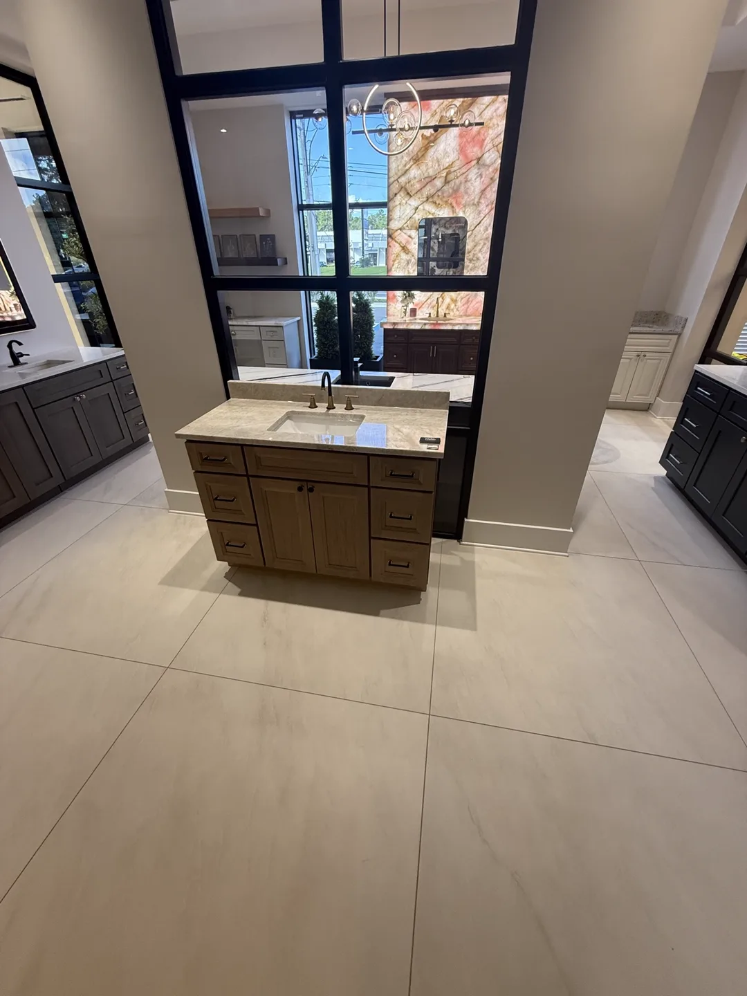 Wood vanity with marble-look top and brushed brass faucet — design idea from a supplier showroom