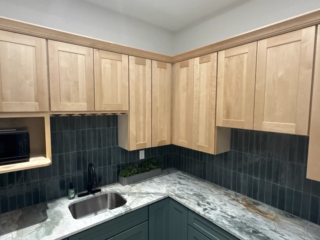 Floor-to-ceiling light wood pantry cabinets with coffee station and marble counters — design idea from a supplier showroom