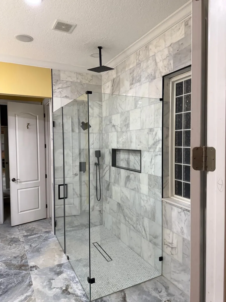 Marble-look tile paired with warm flooring tones by Braga Remodeling